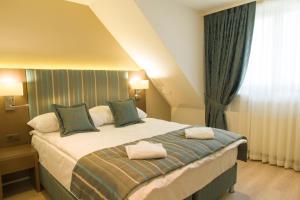ein Schlafzimmer mit einem Bett mit zwei Handtüchern darauf in der Unterkunft Résidence de l'Ours in Lausanne