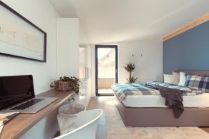 1 dormitorio con 1 cama y escritorio con ordenador portátil en Simply Home Apartments, en Ueberackern
