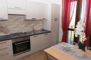 uma cozinha com armários brancos e um forno com placa de fogão em Appartamenti Brufa Civico 13/17 em Brufa