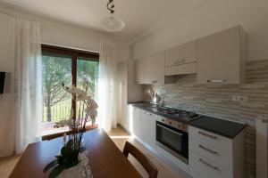a kitchen with white cabinets and a table and a window at Appartamenti Brufa Civico 13/17 in Brufa