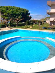 uma grande piscina com água azul em Glyfa Beach Hotel em Vartholomión