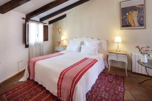 a hotel room with a bed, table, lamps and a painting on the at Alavera de los Baños in Ronda