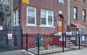 ブロンクスにあるTwo Bedroom Apartment - North East Bronxのレンガ造りの建物前の黒い柵