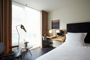 a bedroom with a bed and a desk and a window at B&B Gregorius in Utrecht