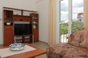 - un salon avec un canapé et une télévision dans l'établissement Apartment Marina, à Postira
