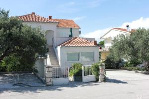 une maison blanche avec un portail dans une allée dans l'établissement Apartment Marina, à Postira