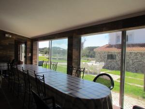 a dining room with a table and chairs and a large window at Quinta Do Forno in Vimeiro