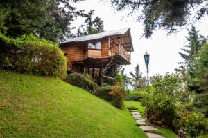 uma casa na árvore com uma varanda numa colina em Los Naranjos Town Houses em Los Naranjos