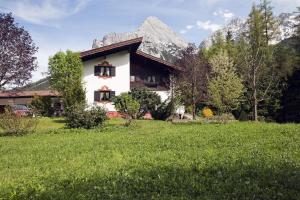 una casa in un campo con montagne sullo sfondo di Gästehaus Sylvia a Biberwier