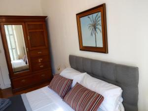 Schlafzimmer mit einem Bett, einer Kommode und einem Spiegel in der Unterkunft Charmant appartement au centre de Nice in Nizza