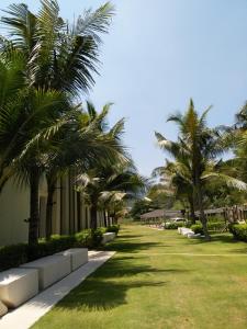 a row of palm trees next to a building at By The Sea Duplex Condo in Batu Ferringhi