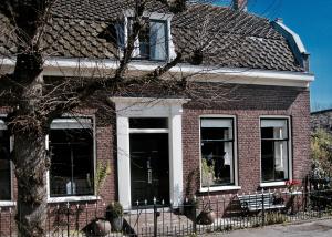 uma casa de tijolos vermelhos com uma porta preta em House of Cocagne em Kockengen