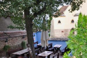 a patio with tables and umbrellas next to a pool at Casa Saseasca in Sighişoara