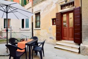 a table and chairs with an umbrella in front of a building at Ca' Etta in Venice