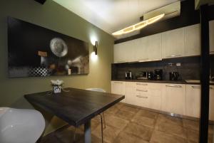 una cucina con un tavolo di legno e mobili bianchi di Andromeda Suites ad Atene