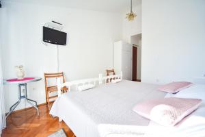 1 dormitorio con 2 camas y TV en la pared en Room Marijana, en Zadar