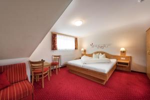 um quarto com uma cama, uma secretária e uma cadeira em Das Wismeyer em Obertauern