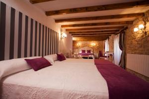 a hotel room with a large bed and a large window at Hotel Rural La Torre de Bisjueces in Bisjueces
