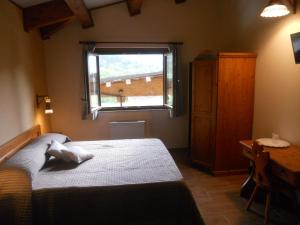 a bedroom with a bed and a window at La Locanda Del Lago Lucciola in Villalago