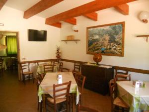 a restaurant with tables and chairs and a painting on the wall at La Locanda Del Lago Lucciola in Villalago