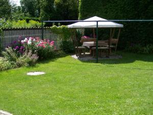um jardim com uma mesa e um guarda-chuva na relva em Ferienwohnung Ahrendt em Dresden