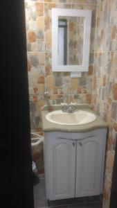 a bathroom with a sink and a mirror at Apartaestudios El Cable in Manizales