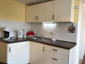 a small kitchen with white cabinets and a sink at Zum Nordstrand in Prerow
