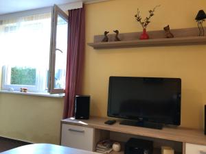 a living room with a flat screen tv and a window at Zum Nordstrand in Prerow