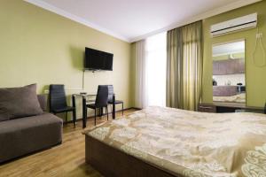 una camera con letto e tavolo con sedie di Apartment Orbi Rezidence a Batumi
