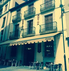 a building with tables and chairs in front of it at Hostal Virgen de la Encina in Ponferrada