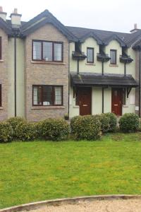 une maison avec une cour d'herbe devant elle dans l'établissement Lough Rynn House, à Mohill