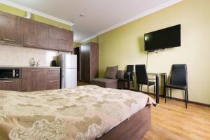 una camera con letto e una cucina con tavolo di Apartment Orbi Rezidence a Batumi