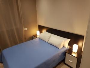 a bedroom with a large bed with two night stands at Vivienda Reina Victoria in Huelva