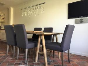 stół jadalny z krzesłami i telewizor w obiekcie Sylthaus w mieście Archsum