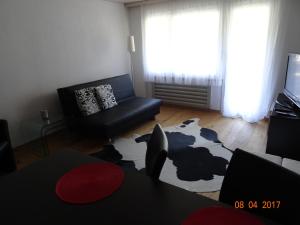 a living room with a couch and a cow rug at Haus Montanara in Unterbäch