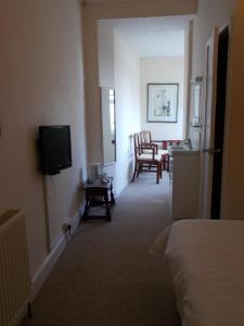 a hotel room with a bed and a television at Glenleigh Bed and Breakfast in Marazion