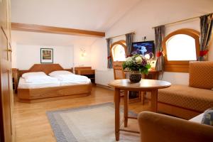 a hotel room with two beds and a table at Gästehaus Reiter in Golling an der Salzach