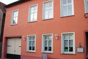 un edificio rojo con ventanas blancas y una puerta blanca en Hotel Bürgerstube en Hitzacker