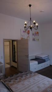 Schlafzimmer mit einem Bett und einem Kronleuchter in der Unterkunft Ferienwohnung Anisa in Rust