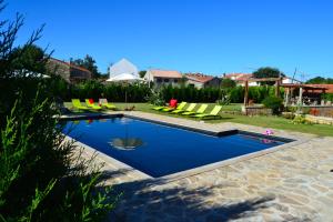 Vale das Éguas的住宿－Carya Tallaya - Casas de Campo，一个带椅子的庭院和房子的游泳池