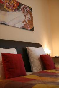 Schlafzimmer mit einem Bett mit roten und weißen Kissen in der Unterkunft La Maison ERNENWEIN in Obermodern
