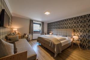ein Schlafzimmer mit einem großen Bett und einem Sofa in der Unterkunft Gasthof Hotel Hauslwirt in Golling an der Salzach