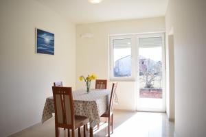 a dining room with a table and chairs and a window at Apartment Mary in Porat