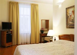 a hotel room with a bed and a television at Old Riga Boutique Hotel "Vecriga" in Riga