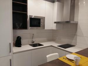 a white kitchen with a sink and a microwave at AiA EXCLUSIVE APARTMENTS in Granada +96 photos