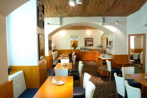 a restaurant with wooden tables and white chairs at Máchova in Prague