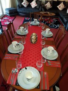 a wooden table with plates and glasses on it at Edinburgh City Deluxe Apartment in Edinburgh