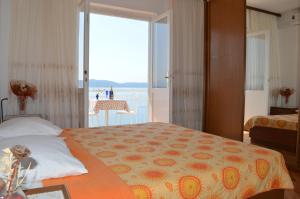 a bedroom with a bed with a view of the ocean at Apartments Majstrovic in Živogošće