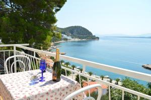 a table with a bottle of wine sitting on a balcony at Apartments Majstrovic in Živogošće