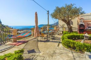 een patio met een hangmat en een tafel en stoelen bij Villa Nena Apartments Sutomore in Sutomore